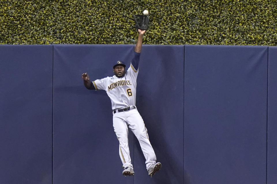 Milwaukee Brewers center fielder Lorenzo Cain (6) can't make the catch on a solo home run hit by Miami Marlins' Miguel Rojas during the first inning of a baseball game, Saturday, May 8, 2021, in Miami. (AP Photo/Lynne Sladky)