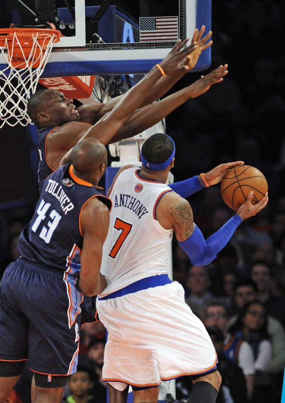 Charlotte Bobcats' Anthony Tolliver (43) and Bismack Biyombo guard New York Knicks' Carmelo Anthony (7) during the fourth quarter of an NBA basketball game, Friday, Jan. 24, 2014, at Madison Square Garden in New York. Anthony scored 62 points as the Knicks defeated the Bobcats 125-96. (AP Photo/Bill Kostroun)