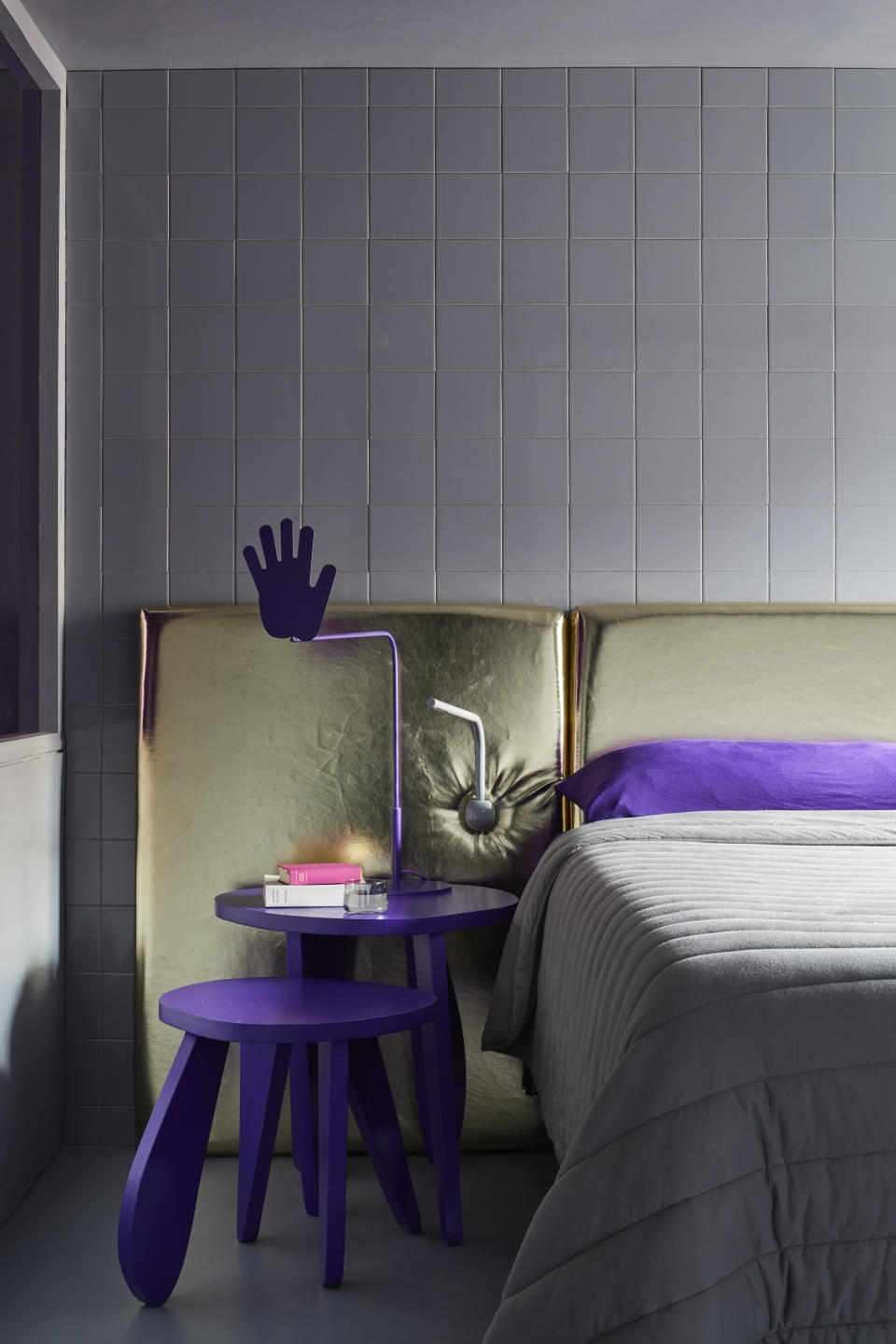 A bedroom with a gold and purple scheme