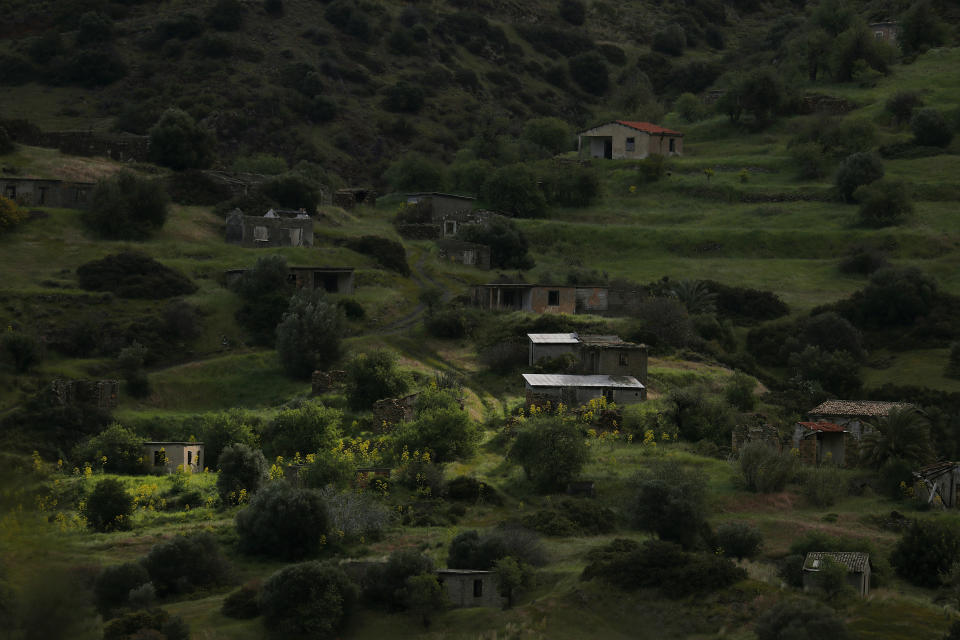 The abandoned village of Varisia is seen inside the U.N controlled buffer zone that divide the Greek, south, and the Turkish, north, Cypriot areas since the 1974 Turkish invasion, Cyprus, on Friday, March 26, 2021. Cyprus' endangered Mouflon sheep is one of many rare plant and animal species that have flourished a inside U.N. buffer zone that cuts across the ethnically cleaved Mediterranean island nation. Devoid of humans since a 1974 war that spawned the country’s division, this no-man's land has become an unofficial wildlife reserve. (AP Photo/Petros Karadjias)