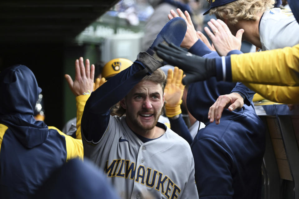Milwaukee Brewers' Brice Turang (0) celebrates in the dugout with teammates after scoring during the eighth inning of a baseball game against the Chicago Cubs, Saturday, April 1, 2023, in Chicago. (AP Photo/Quinn Harris)