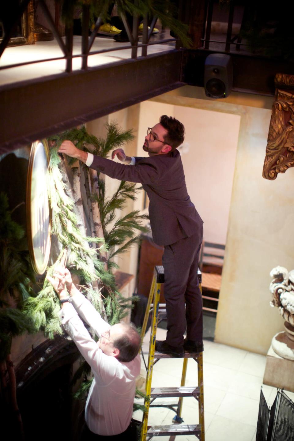 Billy and his father decorate the fireplace in front of which the couple recited their vows.