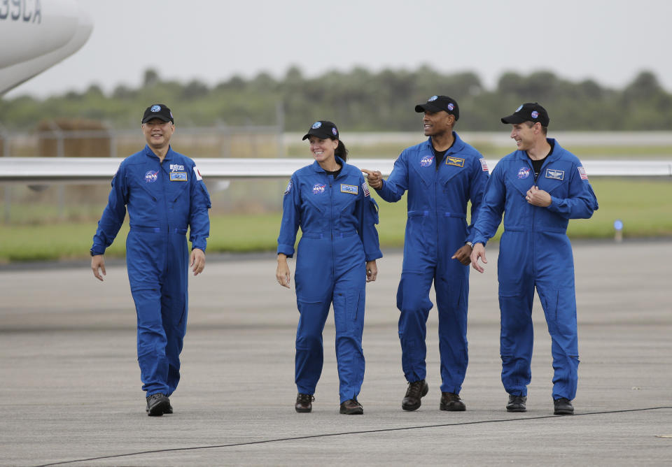 Astronaut Soichi Noguchi, of Japan, from left, NASA Astronauts Shannon Walker, Victor Glover and Michael Hopkins walk after arriving at Kennedy Space Center, Sunday, Nov. 8, 2020, in Cape Canaveral, Fla. The four astronauts will fly on the SpaceX Crew-1 mission to the International Space Station scheduled for launch on Nov. 14, 2020 (AP Photo/Terry Renna)