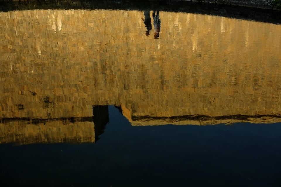 <p>Silhouettes of people are reflected on the water of a pond while they go for a walk, in Pamplona northern Spain, Sept. 28, 2016. (Photo: Alvaro Barrientos/AP) </p>