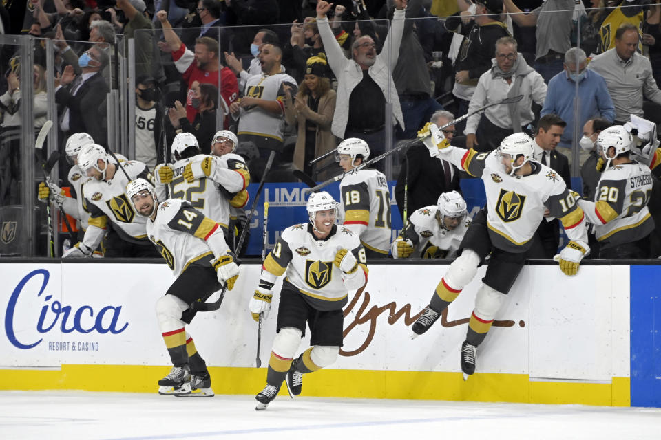 Vegas Golden Knights defenseman Nicolas Hague (14), center Jonathan Marchessault (81) and center Nicolas Roy (10) celebrate after defeating the Anaheim Ducks in a shootout in an NHL hockey game Friday, Oct. 29, 2021, in Las Vegas. (AP Photo/David Becker)