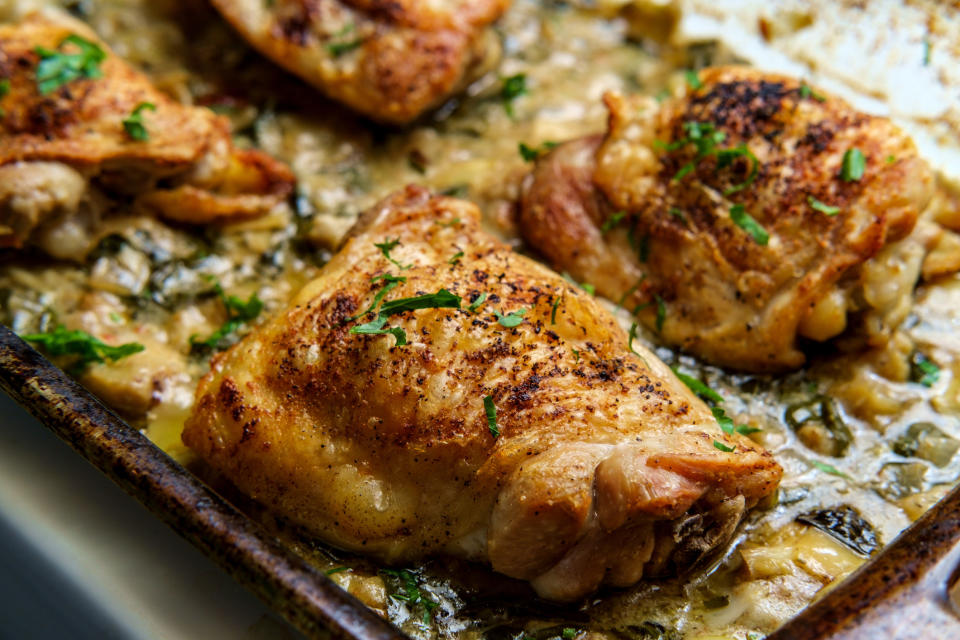 Crispy baked chicken thighs in a creamy spinach artichoke heart sauce.