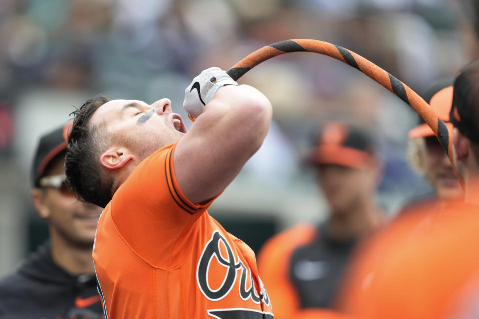 Baltimore Orioles' James McCann pretends to drink from a tube in the dugout after hitting a home run against the Detroit Tigers in the second inning during the first baseball game of a doubleheader, Saturday, April 29, 2023, in Detroit. Fans are calling the celebration the dong bong. (AP Photo/Paul Sancya)