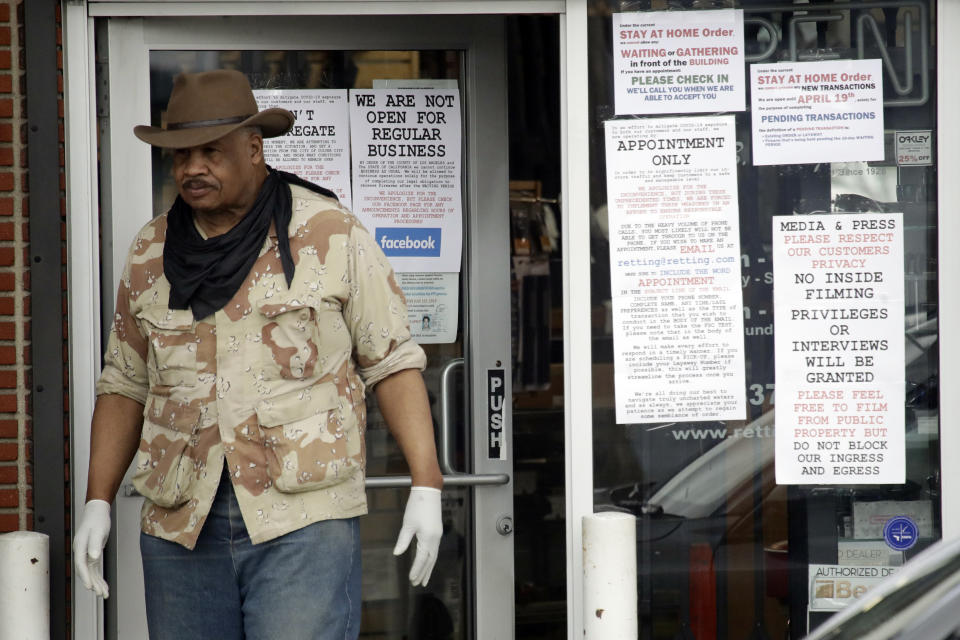 CORRECTS TO CULVER CITY, INSTEAD OF LOS ANGELES An employees stands at the entrance to a guns shop Tuesday, March 24, 2020, in Culver City, Calif. Los Angeles County Sheriff Alex Villanueva said he would like to see gun shops shut down. "We will be closing them, they are not an essential function," Villanueva said. Adding guns to households where more people are at home during a crisis increases the risk that someone will be shot, he said. (AP Photo/Marcio Jose Sanchez)