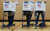 People fill out ballots at a polling location for the 2016 US presidential election in a public school in Astoria. Photo: AAP