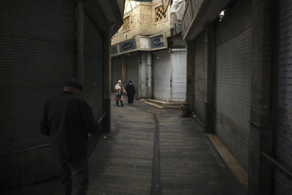 People walk through a closed bazaar in northern Tehran, Iran, Sunday, Nov. 22, 2020. Iran on Saturday shuttered businesses and curtailed travel between its major cities, including the capital of Tehran, as it grapples with the worst outbreak of the coronavirus in the Mideast region. (AP Photo/Vahid Salemi)