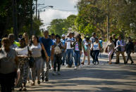 In this April 26, 2019, photo, Cubans wait their turn to enter Panama's embassy to apply for travel visas to Panama, in Havana, Cuba. The surge over the past several months has been propelled in part by loosened traveled restrictions in Central America and deteriorating living conditions in Cuba. (AP Photo/Ramon Espinosa)