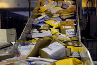 Parcels jam a conveyor belt at the United States Postal Service sorting and processing facility, Thursday, Nov. 18, 2021, in Boston. On the busiest days, about 170,000 packages are processed at the facility. Last year's holiday season was far from the most wonderful time of the year for the beleaguered U.S. Postal Service. Shippers are now gearing up for another holiday crush.(AP Photo/Charles Krupa)