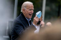 Democratic presidential candidate former Vice President Joe Biden holds up his face mask as he speaks to members of the media outside a voter service center, Monday, Oct. 26, 2020, in Chester, Pa. (AP Photo/Andrew Harnik)