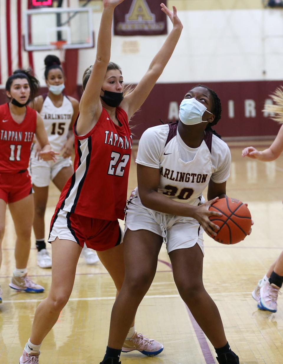 Arlington's Nneoma Ezeilo (30) tries to go up for a shot in front of Tappan Zee's Brooke Comito (22) during girls basketball action at Arlington High School in Freedom Plains Jan. 26, 2022. Tappan Zee won the game 57-47.