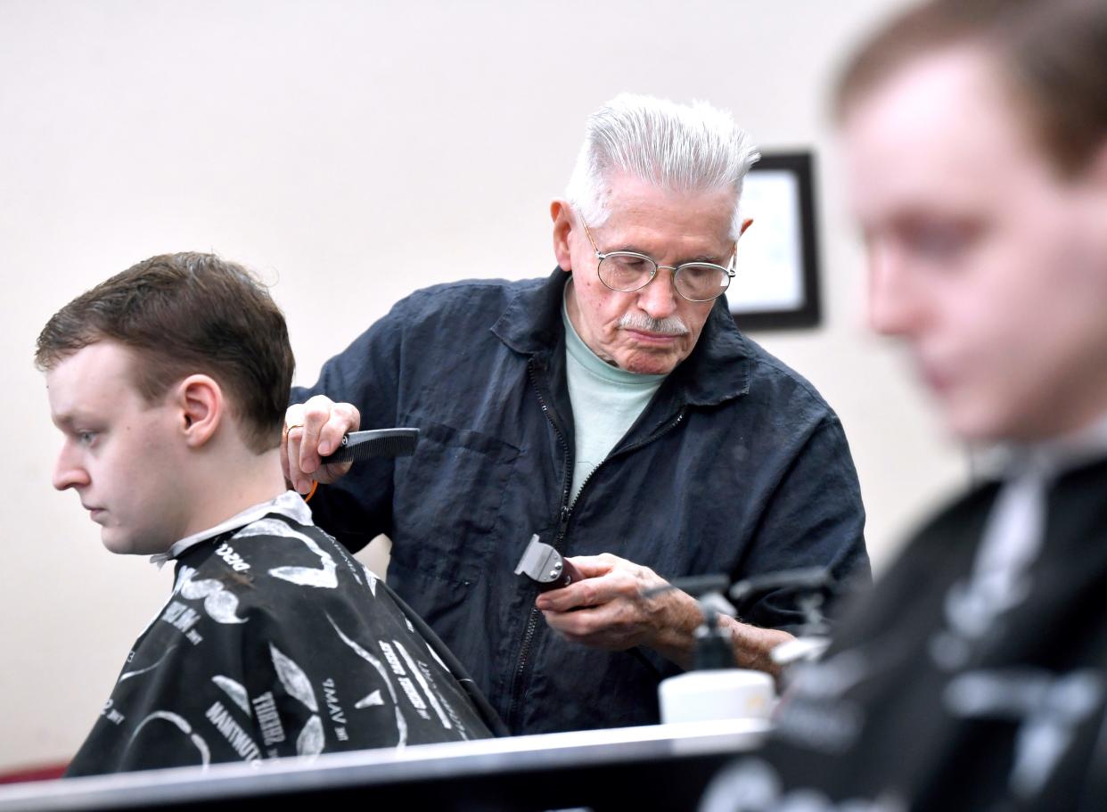 Teddy Gifford pauses momentarily while giving Logan Schoonover a haircut Thursday at River Oaks Barber Shop. "Teddy the Barber" has worked his Oster Model 10 clippers for more than 63 years.