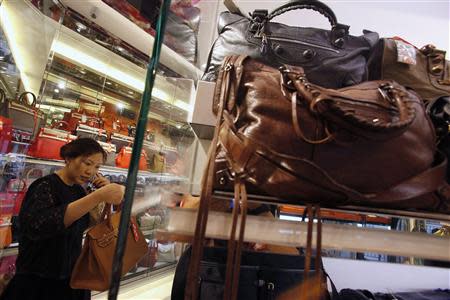 A customer checks a luxury handbag at a Milan Station outlet in Hong Kong September 2, 2013. REUTERS/Bobby Yip