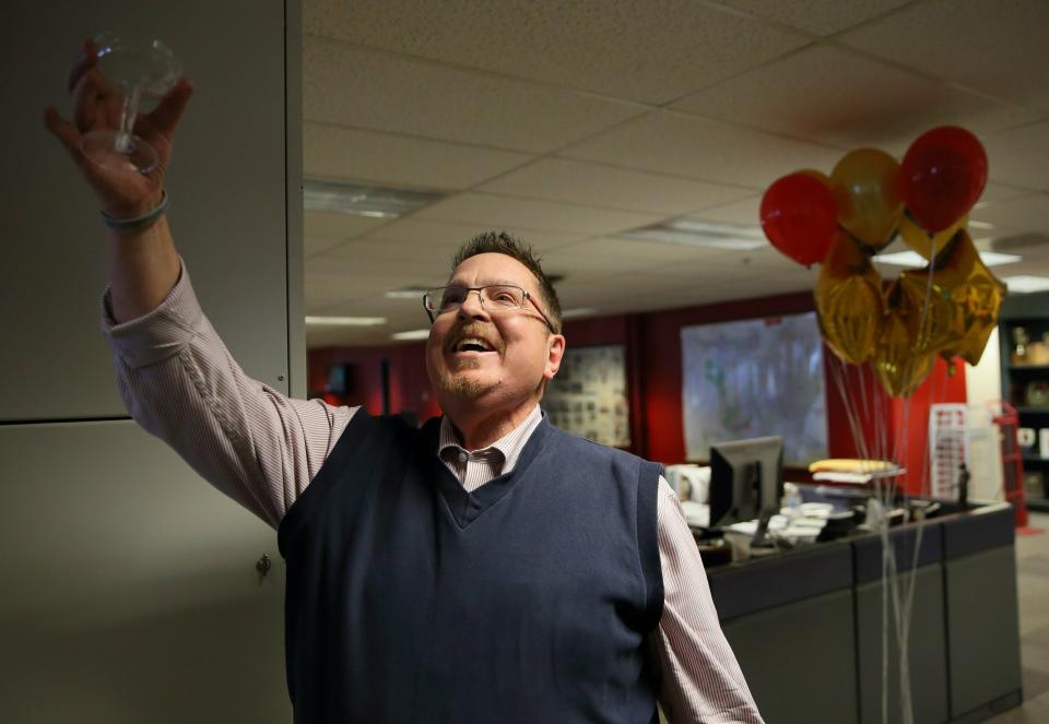 St. Louis Post-Dispatch metro columnist Tony Messenger raises his glass after throwing back a celebratory glass of champagne in the newsroom at the St. Louis Post-Dispatch in St. Louis, Mo. after it was announced he won the 2019 Pulitzer Prize in Commentary Monday, April 15, 2019. (David Carson/St. Louis Post-Dispatch via AP)