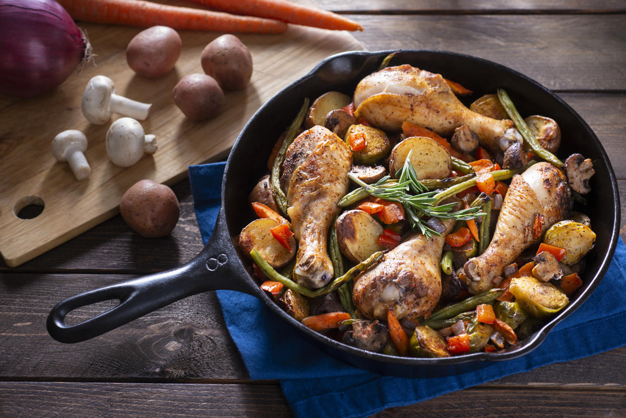 caast iron pan filled with chicken, potatoes and veggies.