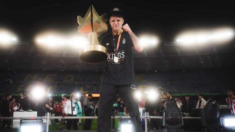 El Barrio president Adri Contreras holds the golden Kings League championship cup after his team won the final.