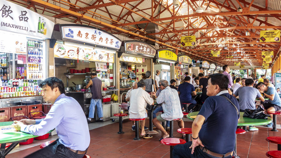 Singapore, Chinatown, July 11, 2019: Lunchtime patrons eating at Maxwell Food Centre in the Chinatown district of Singapore, one of the most popular of Singapore's many hawker centres with residents and visitors