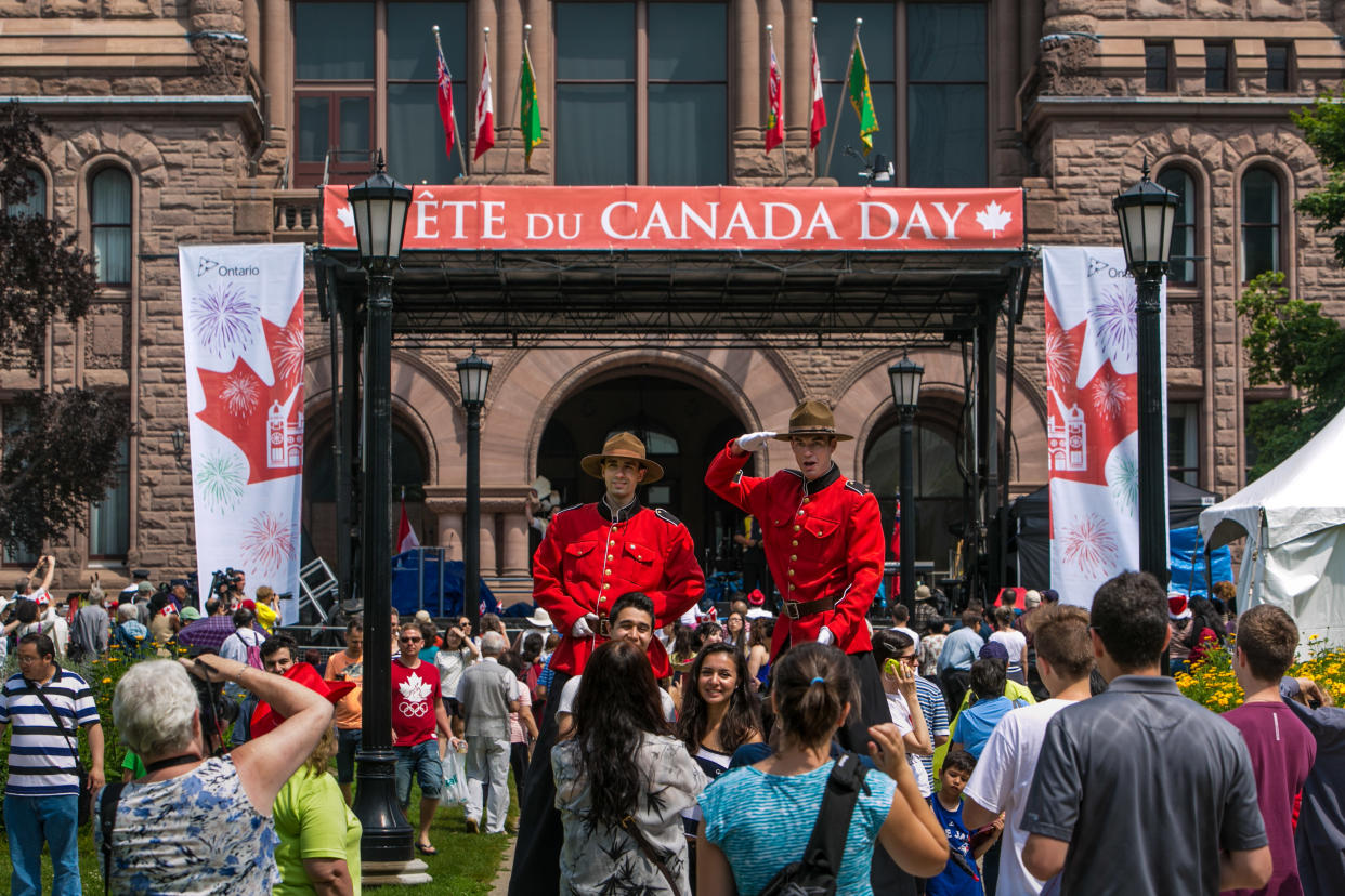 TORONTO, CANADA - JULY 1:  A crowd gathers for the Canada Day celebration on the lawn of the Legislative Building at Queen's Park on July 1, 2014 in Toronto, Ontario, Canada. Canada's most populous city is undergoing a major economic boom with high-rise construction and renovation projects underway throughout the downtown and outlying neighborhoods. (Photo by George Rose/Getty Images)