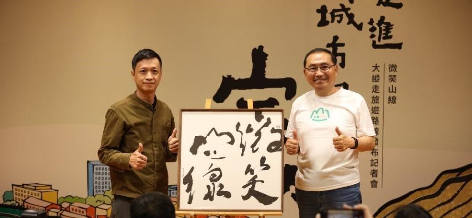 《圖說》青年書法藝術家徐經綸跟市長一同揭示微笑山線服務據點識別牌。〈觀旅局提供〉