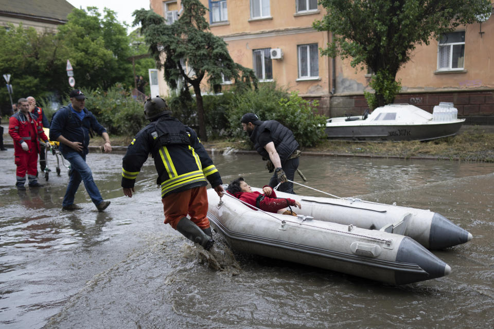 help rush to safety an injured civilian evacuee who had came under fire from Russian forces while trying to flee by boat from the Russian-occupied east bank of a flooded Dnieper River to Ukrainian-held Kherson, on the western bank in Kherson, Ukraine, on Sunday, June 11, 2023. (AP Photo)
