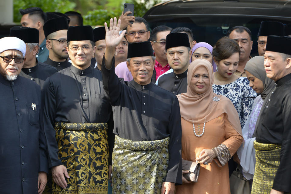 FILE PHOTO: In this March 1, 2020, file photo, Muhyiddin Yassin, center, waves with his family and supporters as he prepares to leave his house for the palace to swear in as new prime minister, in Kuala Lumpur, Malaysia. (AP Photo/Johnshen Lee, File)