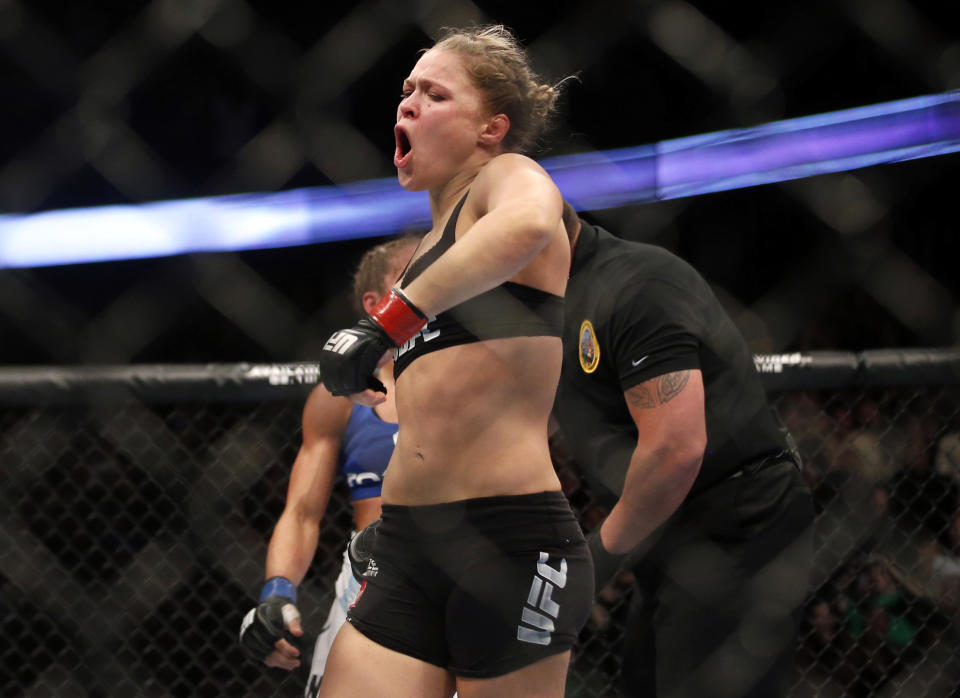 Ronda Rousey celebrates defeating Liz Carmouche after their UFC 157 women's bantamweight championship mixed martial arts match in Anaheim, Calif., Saturday, Feb. 23, 2013. Rousey won the first women’s bout in UFC history, forcing Carmouche to tap out in the first round. (AP Photo/Jae C. Hong)