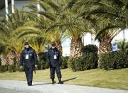 Russian police officers walk past a row of palm trees while taking in the sunny mild temperatures before the 2014 Sochi Winter Olympics in Sochi, Russia on Tuesday, Feb. 4, 2014. (AP Photo/The Canadian Press, Nathan Denette)