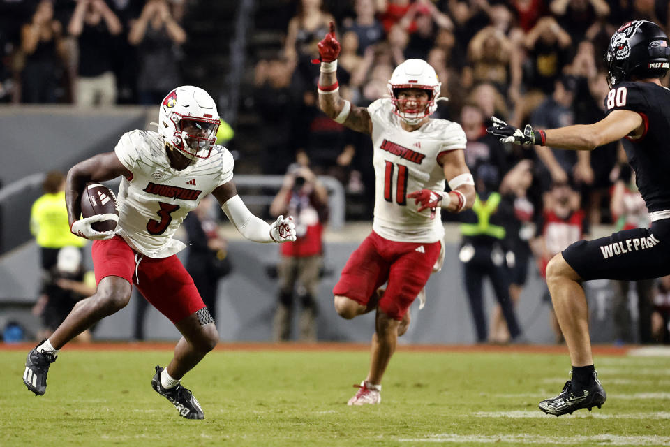 Louisville's Quincy Riley (3) runs with an interception as Cam'Ron Kelly (11) directs the return with North Carolina State's Bradley Rozner (80) defending during the second half of an NCAA college football game in Raleigh, N.C., Friday, Sept. 29, 2023. (AP Photo/Karl B DeBlaker)