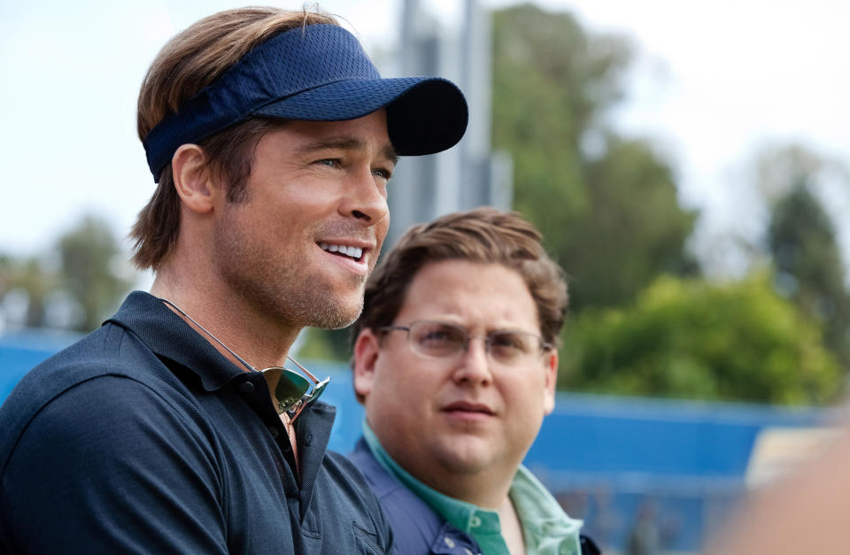 Brad Pitt smiling while Jonah Hill looks at him