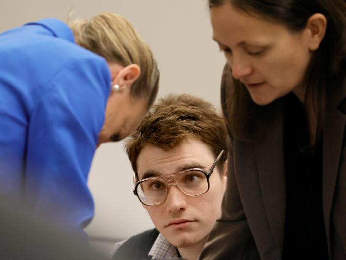 Marjory Stoneman Douglas High School shooter Nikolas Cruz is shown at the defense table as Assistant Public Defender Melisa McNeill, left, and sentence mitigation specialist Kate O'Shea, a member of the defense team, speak during the penalty phase of the trial of Marjory Stoneman Douglas High School shooter Nikolas Cruz at the Broward County Courthouse in Fort Lauderdale on Monday, Aug.  22, 2022.