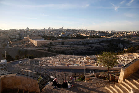 Palestinian women sit at the look-out point of Mount Olives opposite to the Dome of the Rock and Jerusalem's Old City December 4, 2017. REUTERS/Ronen Zvulun