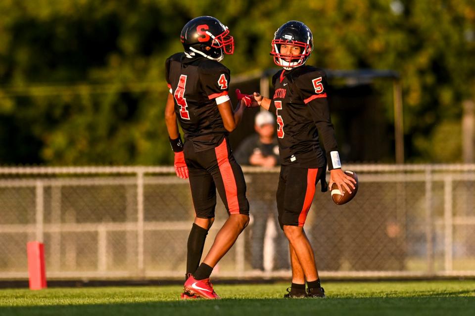 Sexton's Joseph Pizzo, right, celebrates his touchdown against Charlotte with teammate Hurley Young during the fourth quarter on Friday, Sept. 15, 2023, at Sexton High School in Lansing.