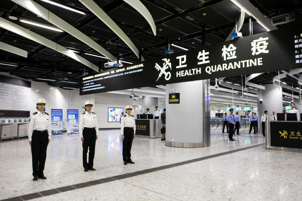 Officers stand under a Health Quarantine sign in the Mainland Port Area at West Kowloon Station, which houses the terminal for the Guangzhou-Shenzhen-Hong Kong Express Rail Link (XRL) at West Kowloon Station, which houses the terminal for the XRL in Hong Kong, Saturday, Sept. 22, 2018. (Giulia Marchi/Pool Photo via AP)