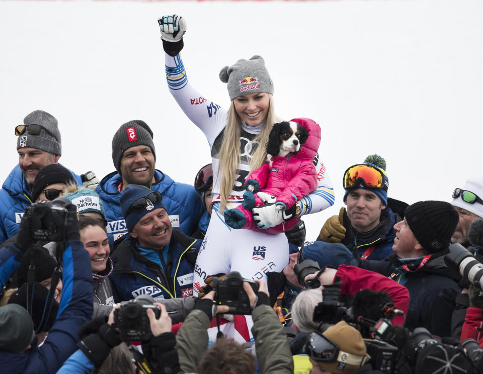 Lindsey Vonn of the United States celebrates with the dog Lucy after the flower ceremony of the women downhill race at the 2019 FIS Alpine Skiing World Championships in Are, Sweden Sunday, Feb. 10, 2019. (Jean-Christophe Bott/Keystone via AP)