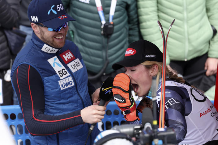 Norway's Aleksander Aamodt Kilde, left, interviews United States' Mikaela Shiffrin after she won an alpine ski, women's World Cup giant slalom race, in Soldeu, Andorra, Sunday, March 19, 2023. (AP Photo/Alessandro Trovati)