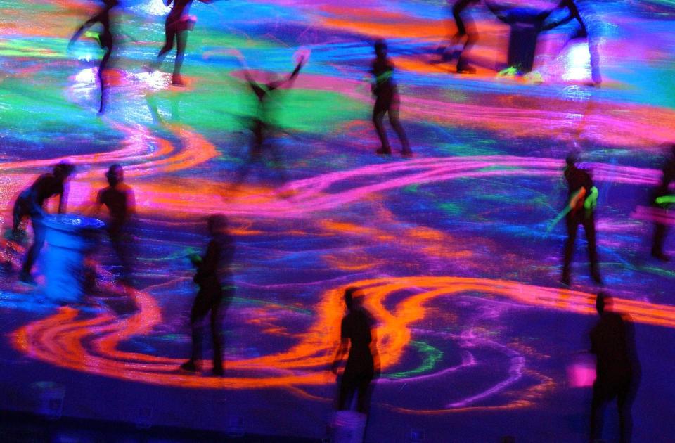 Skaters paint the ice with ultaviolet paint during the Salt Lake 2002 Winter Games closing ceremony at the University of Utah’s Rice-Eccles Stadium on Sunday, Feb. 24, 2002. | Johanna Kirk, Deseret News