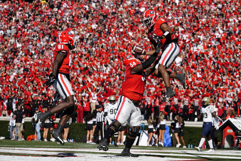 Georgia running back Kenny McIntosh (6) celebrates with offensive lineman Justin Shaffer (54) and wide receiver Marcus Rosemy-Jacksaint (81) after a touchdown in the first half of an NCAA college football game against Charleston Southern Saturday, Nov. 20, 2021, in Athens, Ga. (AP Photo/John Bazemore)