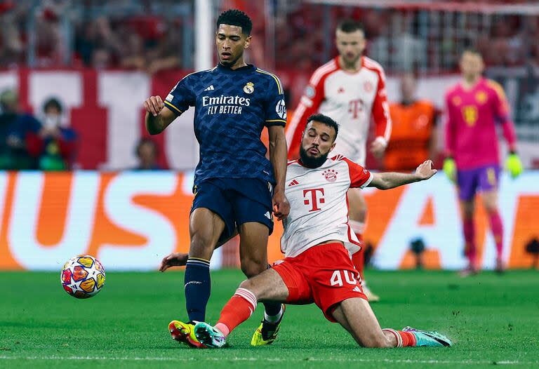 Jude Bellingham disputa el balón con Noussair Mazraoui; Real Madrid y Bayern Munich estiraron la definición de la semifinal hasta el miércoles próximo en el Bernabéu
