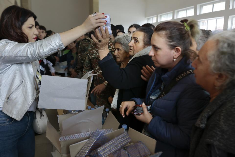 FILE - Ethnic Armenians from Nagorno-Karabakh line up to receive humanitarian aid at a temporary camp in Goris in Syunik region, Armenia, on Tuesday, Sept. 26, 2023. Thousands of Nagorno-Karabakh residents are fleeing their homes after Azerbaijan's swift military operation to reclaim control of the breakaway region after a three-decade separatist conflict. (AP Photo/Vasily Krestyaninov, File)