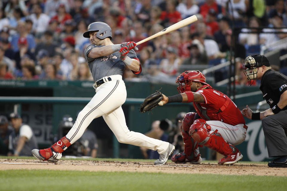 Washington Nationals' Lane Thomas, left, follows through on a solo home run during the second inning of a baseball game against the Cincinnati Reds, Saturday, Aug. 27, 2022, in Washington. (AP Photo/Luis M. Alvarez)