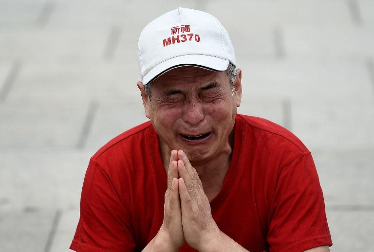 Wen Wancheng, a relative of a passenger on ill-fated Malaysia Airlines flight MH370, cries outside Malaysian Prime Minister Najib Razak's office near Kuala Lumpur