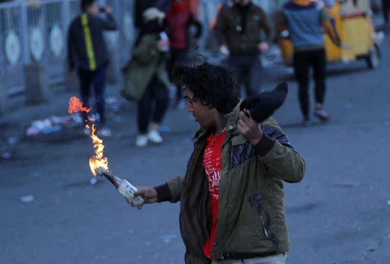 Iraqi demonstrator holds a Molotov cocktail during ongoing anti-government protests in Baghdad