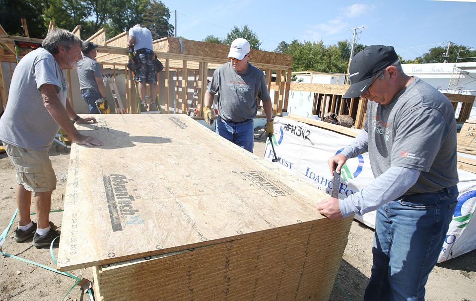 Chuck Abbott (left) works with volunteers David Tucker and John Jennet from First Interstate to build Habitat for Humanity houses at Wilmoth Street Wednesday, Sept. 13, 2023, in Ames.