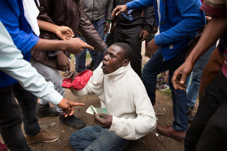 A man holds his South African identity document after being attacked by a mob in Pretoria, South Africa, February 24, 2017. REUTERS/ James Oatway.REUTERS/James Oatway