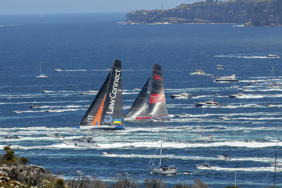 Lead boats, LawConnect, left, and Wild Oats XI sail past North Head soon after the start of Sydney to Hobart yacht race in Sydney, Australia, Monday, Dec. 26, 2022. (Jeremy Ng/AAP Image via AP)