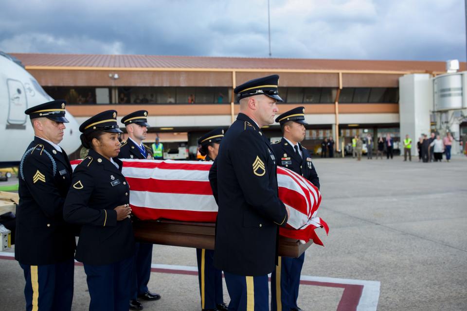 Staff Sgt. William Wood’s casket, draped with an American flag is carefully transferred from a plane to the back of a hearse parked on the tarmac at the Tallahassee International Airport Friday, July 29, 2022.