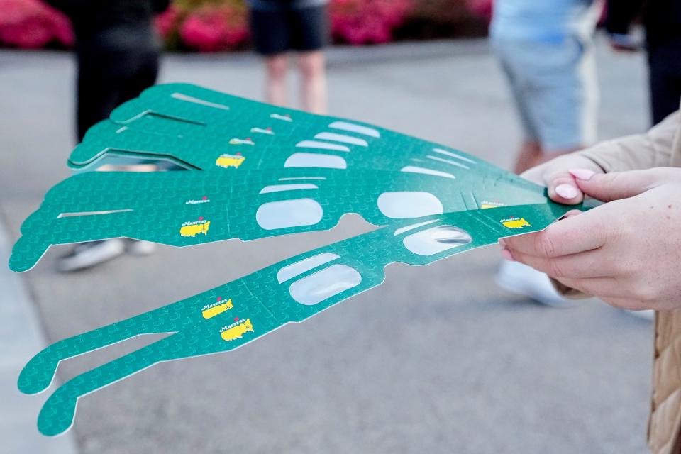 Eclipse glasses are distributed to patrons at the entrance during a practice round for the Masters Tournament golf tournament at Augusta National Golf Club on April 8, 2024.